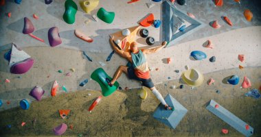 Güçlü Deneyimli Kaya Tırmanışçısı Spor Salonunda Tek başına Bouldering Wall 'a tırmanıyor. Kapalı Spor Salonu 'nda egzersiz yapan, Sağlıklı Yaşam Tarzı Eğitimi İçin Ekstrem Spor Yapan Adam. Arkadan çekim.