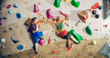 İki Deneyimli Kaya Tırmanışçısı Spor Salonunda Bouldering Wall 'a Tırmanma Çalışması. Kapalı Spor Salonu 'nda egzersiz yapan, Sağlıklı Eğitim İçin Aşırı Spor yapan arkadaşlar. Birbirimize beşlik çakıyoruz..