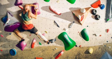 Güçlü Deneyimli Kaya Tırmanışçısı Spor Salonunda Tek başına Bouldering Wall 'a tırmanıyor. Kapalı Spor Salonu 'nda egzersiz yapan, Sağlıklı Yaşam Tarzı Eğitimi İçin Ekstrem Spor Yapan Adam. Arkadan çekim.