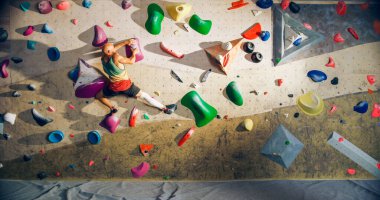 Güçlü Deneyimli Kaya Tırmanışçısı Spor Salonunda Tek başına Bouldering Wall 'a tırmanıyor. Kapalı Spor Salonu 'nda egzersiz yapan, Sağlıklı Yaşam Tarzı Eğitimi İçin Ekstrem Spor Yapan Adam. Arkadan çekim.