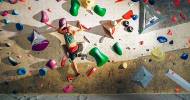 Güçlü Deneyimli Kaya Tırmanışçısı Spor Salonunda Tek başına Bouldering Wall 'a tırmanıyor. Kapalı Spor Salonu 'nda egzersiz yapan, Sağlıklı Yaşam Tarzı Eğitimi İçin Ekstrem Spor Yapan Adam. Arkadan çekim.