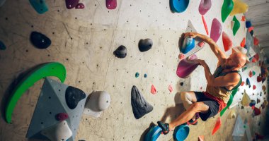 Güçlü Deneyimli Kaya Tırmanışı Spor Salonunda Tek başına Bouldering Wall 'a tırmanıyor. Erkek Spor Salonu Spor Salonu 'nda, Sağlıklı Yaşam Tarzı Eğitimi İçin Olağanüstü Spor Yapıyor.