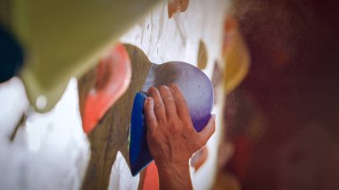 Güçlü Deneyimli Kaya Tırmanışı Spor Salonunda Tek başına Bouldering Wall 'a tırmanıyor. Kapalı Spor Salonu 'nda egzersiz yapan, Sağlıklı Yaşam Tarzı Eğitimi İçin Ekstrem Spor Yapan Adam. Portreyi Kapat