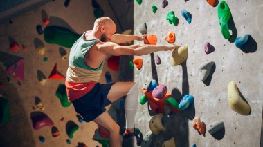 Güçlü Deneyimli Kaya Tırmanışı Spor Salonunda Tek başına Bouldering Wall 'a tırmanıyor. Kapalı Spor Salonu 'nda egzersiz yapan, Sağlıklı Eğitimi İçin Olağanüstü Spor Yapan Adam. Yaşam Tarzı Portresi.