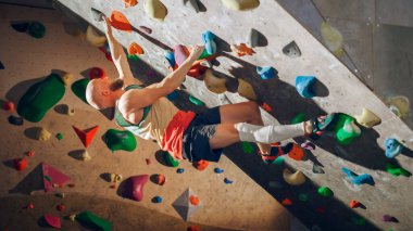 Güçlü Deneyimli Kaya Tırmanışı Spor Salonunda Tek başına Bouldering Wall 'a tırmanıyor. Kapalı Spor Salonu 'nda egzersiz yapan, Sağlıklı Eğitimi İçin Olağanüstü Spor Yapan Adam. Yaşam Tarzı Portresi.