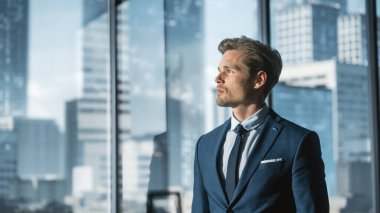 Modern Ofiste Mükemmel Terzi Takımlı Genç İşadamı Gökdelenlerle Büyük Şehir 'de Pencereden Dışarı Bakıyor. Başarılı Finans Yöneticisi Yeni Yatırım Planlama.