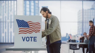 ABD 'de Ulusal Seçim Günü' nde oy verme kabininin yanında oy veren yakışıklı bir gencin portresi. Yetişkin Adamlar ve