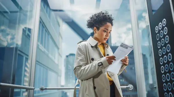 Hermostunut Musta Nainen Asiantuntija Ratsastaa Lasihississä Modernissa Toimistorakennuksessa Hänen Työhaastattelussaan — kuvapankkivalokuva