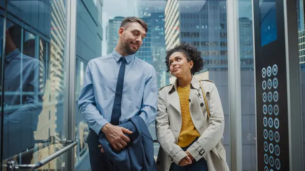 Two Office Colleagues Looking Each Other While Riding Glass Elevator — Stock Photo, Image