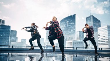 Modern Kentsel Skyline 'lı Büyük Dijital Led Wall Screen' in önünde Hip Hop Dansı yapan Üç Profesyonel Dansçı Grubu