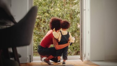 Loving Mother Hugging Adorable Baby Boy at Modern Home Living Room. Cheerful Babysitter Nurturing a Child. Concept of Childhood, New Life, Parenthood.