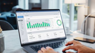 Bilgisayarı kullanarak Bir Kişinin Ellerini Kapat, Haritalar ve Grafiklerle Veri Analizi Yapıyor. Genç adam modern evden çalışıyor, dokunmatik pedi kullanıyor.