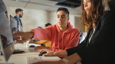 Çeşitli etnik çeşitlilikteki Kadın ve Erkek Öğrenciler Kolej Odasında Oturuyor, Bilgisayarda Okul Projeleri Üzerine İşbirliği Yapıyorlar. Genç Bilginler Çalışması