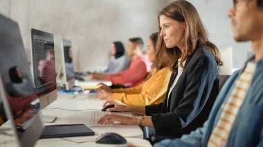 Çeşitli etnik çeşitlilikteki Kadın ve Erkek Öğrenciler Kolej Odasında Oturarak Bilgisayar Bilimi Öğreniyor. Genç Bilginler Bilgi Teknolojisi okuyor