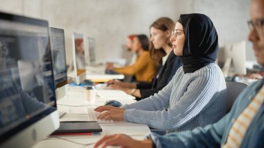 Çeşitli etnik çeşitlilikteki Kadın ve Erkek Öğrenciler Kolej Odasında Oturarak Bilgisayar Bilimi Öğreniyor. Genç Bilginler Bilgi Teknolojisi okuyor