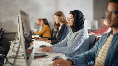 Çeşitli etnik çeşitlilikteki Kadın ve Erkek Öğrenciler Kolej Odasında Oturarak Bilgisayar Bilimi Öğreniyor. Genç Bilginler Bilgi Teknolojisi okuyor