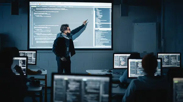 在黑暗学院的教室里 教师为不同种族的男女学生举办计算机科学讲座 投影仪与 — 图库照片