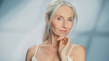 Kameraya Bakan ve Harika Gülümseyen Güzel Yaşlı Kadın Portresi. Yaşlı Güzellik. Cilt bakımı için Yaşlılık Konsepti