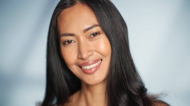 Kadın Güzellik Portresi. Güzel Asyalı Esmer Kadın pozu, Kameraya Bakış, Gülümseme. Sağlık, Saç ve Makyaj ve Cilt Bakımı