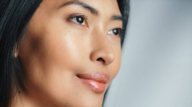 Güzel Asyalı Kadın yukarı bakıyor. Kadın, güzelliğinin, kendine olan saygısının ve sağlığının tadını çıkarıyor. Doğal Kozmetik Teni Ürünleri. Yakın plan Portre