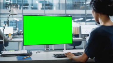 Chroma Key Green Screen Mock Up ile Masaüstü Bilgisayarı 'nda çalışan bir iş kadınının Omuz Üstü Çekimi. Dijital Projeler Yöneticisi