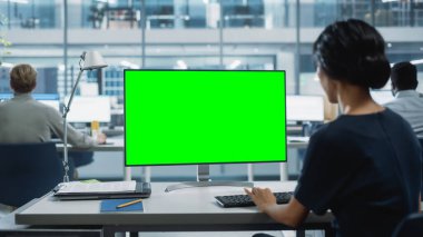 Chroma Key Green Screen Mock Up ile Masaüstü Bilgisayarı 'nda çalışan bir iş kadınının Omuz Üstü Çekimi. Dijital Projeler Yöneticisi