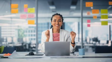 Genç Başarılı Siyah Proje Yöneticisi Masasında Otururken Dans Ediyor ve Gülümsüyor. Yaratıcı Dizüstü Bilgisayarda Güzel Kadın Uzman Çalışmaları