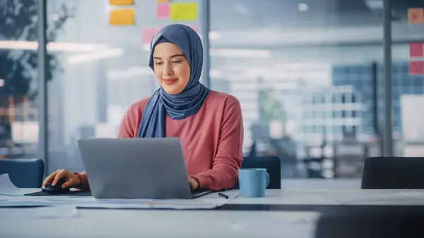 stock image Modern Office: Portrait of Young Muslim Businesswoman Wearing Hijab Works on Laptop, Does Data Analysis, Website Design, Creative Development. Digital