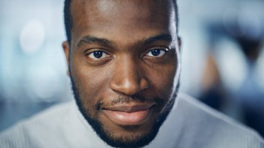 Koyu Kahverengi Gözlü Yakışıklı Siyah Adam 'ın yakın plan portresi, Süslü Sakal, Şık Beyaz Balıkçı yaka yaka, Göz Kırpma ve Mükemmel Gülümseme Gösterme