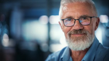 Kameraya Bakan ve Gülümseyen Başarılı Orta YaşIı Sakallı Adam Portresi. Yakışıklı kıdemli iş adamı ceketini giyiyor Yükselen gözler giyiyor, eğleniyor.