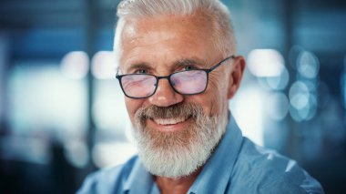 Kameraya Bakan ve Gülümseyen Başarılı Orta YaşIı Sakallı Adam Portresi. Yakışıklı kıdemli iş adamı ceketini giyiyor Yükselen gözler giyiyor, eğleniyor.