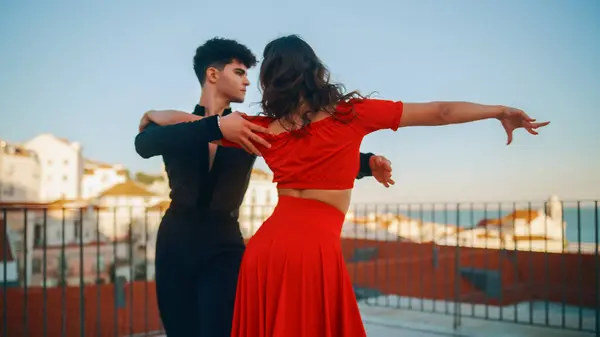 Beautiful Couple Dancing a Latin Dance Outside the City with Old Town in the Background. Sensual Dance by Two Professional Dancers on a Sunset in