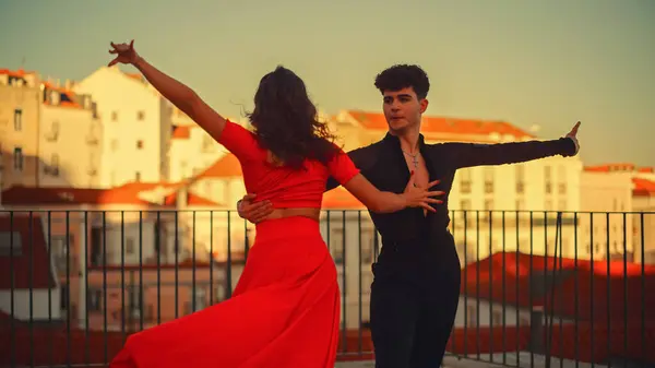 Beautiful Couple Dancing a Latin Dance Outside the City with Old Town in the Background. Sensual Dance by Two Professional Dancers on a Sunset in