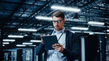 Tablet Bilgisayar kullanan başarılı veri merkezi bilişim uzmanı. Sistem Yöneticisinin çalıştığı Sunucu Çiftliği Bulut Hesaplama Tesisi. Veri Koruması