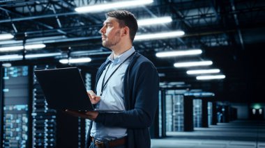 Laptop kullanan başarılı veri merkezi bilişim uzmanı. Sistem Yöneticisinin çalıştığı Sunucu Çiftliği Bulut Hesaplama Tesisi. Veri Koruması