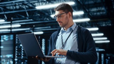 Laptop kullanan başarılı veri merkezi bilişim uzmanı. Sistem Yöneticisinin çalıştığı Sunucu Çiftliği Bulut Hesaplama Tesisi. Veri Koruması