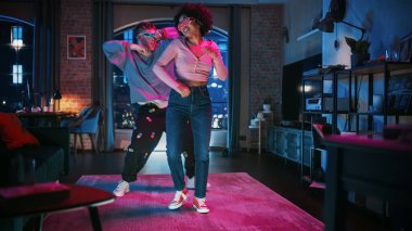 Gayri resmi kıyafetlerde çok ırklı güzel bir çift ve Parlak Gözlüklü, Dans ve Daire Dairesinde Bir Partileri Var