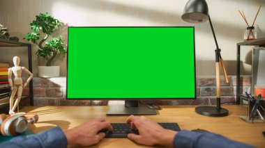 Yeşil Ekran Mock Up Ekranı ile Masaüstü Bilgisayarında Çalışan Bir Adamın POV İlk İnsan Görünümü. Bir Masada Oturan Erkek, İnternet Tarama ve Kullanım