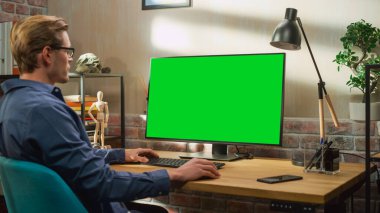 Green Screen Mock Up Ekranı ile Evden Çalışan Genç Yakışıklı Adam. Yaratıcı Erkek Sosyal Medya Denetleme, İnternet Taraması