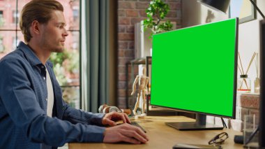 Green Screen Mock Up Ekranı ile Evden Çalışan Genç Yakışıklı Adam. Erkek Denetleme Kurumsal Hesaplar, Mesajlaşma Meslektaşları