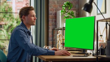 Green Screen Mock Up Ekranı ile Evden Çalışan Genç Yakışıklı Adam. Erkek Denetleme Kurumsal Hesaplar, Mesajlaşma Meslektaşları