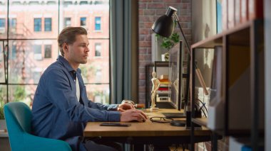 Tasarım Yazılım ile Evden Çalışmak İçin Oturan Genç Yakışıklı Adam. Yaratıcı Erkek Sosyal Medya Denetleme, İnternet Taraması