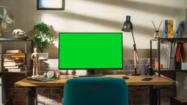 Masaüstü Bilgisayar Monitörü Yeşil Ekran Kromakey Mock Up Ekranı ile Bir Masanın Üzerinde Duruyor. Lambalı, Defterli, Konforlu Boş Daire