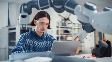Dizüstü bilgisayarda Erkek Geliştirici Programlama Robotik Kol. 3D CAD Yazılım kullanarak Robotik Mühendis Tasarımları Oluşturdu. Atılım Projeleri ve Bilgisayar