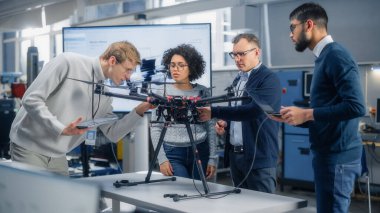 Havacılık Mühendisleri Ekibi yeni bir İHA üzerinde çalışıyor, tartışıyorlar, Bilimsel Laboratuvarda Dizüstü bilgisayar kullanıyorlar. Çeşitli bilim adamları konuşuyor ve inceliyor.