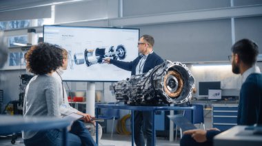 Çalışan Genç Bilim Adamları Grubu: Fabrika Toplantı Odasında Motor Denetleme. İnsanlar Baş Mühendis 'le beyin fırtınası yapıyor. Güvenilir Endüstri