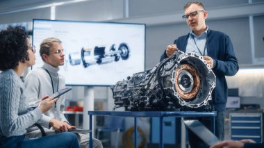 Muhtelif uzmanlar Motor 'un etrafında toplanıyor ve Seminer sırasında Erkek Baş Mühendis' le tartışıyorlar. Araştırma, Geliştirme, Görselleştirme