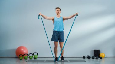 Fitness Course Video Stream with Young Athletic Personal Trainer Explaining Core Strengthening Workout Routine with a Rubber Band. Fit Online Coach