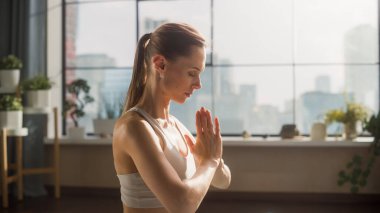 Young Beautiful Female Exercising, Practising Meditation in the Morning in Her Bright Sunny Loft Apartment. Healthy Lifestyle, Fitness, Wellbeing and