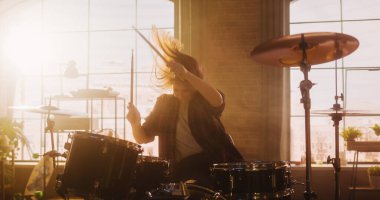 Beautiful Young Drummer Playing at a Band Rehearsal, Doing Tricks with Drumsticks. Learning Drum Solo on Drums and Cymbals in Sunny Living Room Loft
